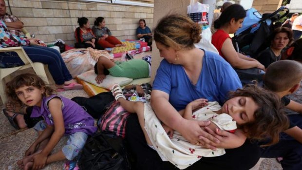 Iraqi Christians who fled the violence in the village of Qaraqush, about 30 kilometres east of the northern province of Nineveh, rest upon their arrival at Saint-Joseph's Church in the Kurdish city of Arbil.