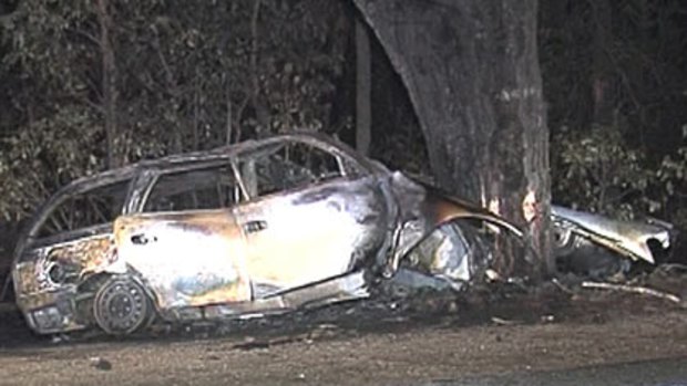 The front of the car lies wrapped around a tree as police examine the wreckage of the family car.