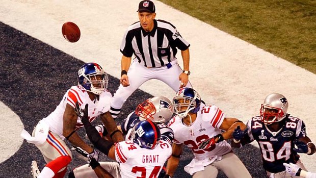 Desperate play ... New York Giants defenders (in white) knock down the football from Aaron Hernandez of the New England Patriots in the final play of the game.