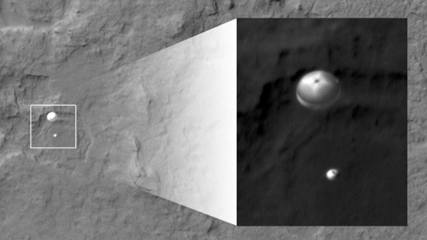 Touchdown ... In this image, NASA's Curiosity rover and its parachute, left, descend to the Martian surface.