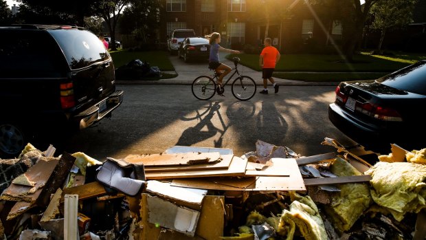 Kids play in the street as the clean up continues in Pearland, Texas in the wake of the downgraded Hurricane Harvey.