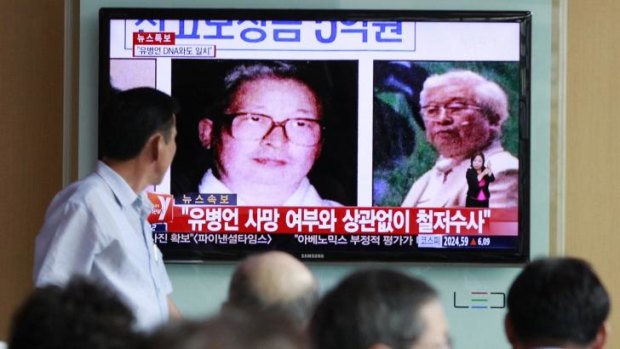 People watch a TV news broadcast showing images of Yoo Byung-eun on a screen at a Seoul railway station.