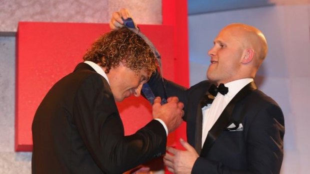 Matt Priddis is presented with the 2014 Brownlow Medal by Gary Ablett of the Suns on Monday night.