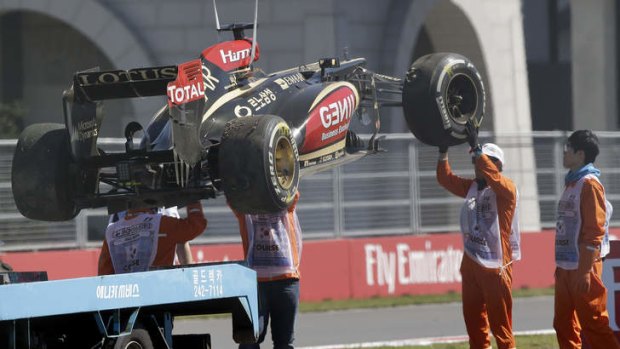 Track marshals lift Lotus driver Kimi Raikkonen's car after he crashed during the first practice session for the Korean Formula One Grand Prix.