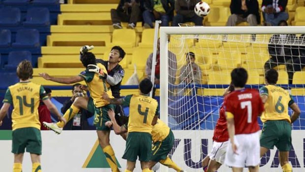 Mile Jedinak scores a goal past South Korea's goalkeeper Jung Sung-ryong.