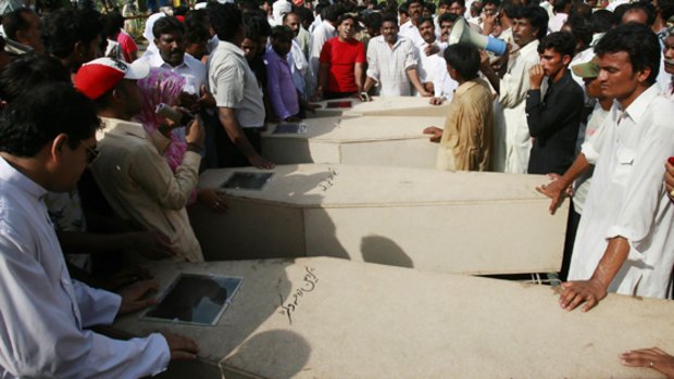 Relatives lay out the caskets of the victims in Gojra.