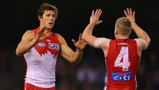 Kurt Tippett of the Swans celebrates with Daniel Hannebery after kicking a goal during the round 19 AFL match.