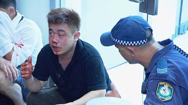 Bloodied and bruised: police help a man early on Sunday morning during an operation targeting alcohol-related crime.