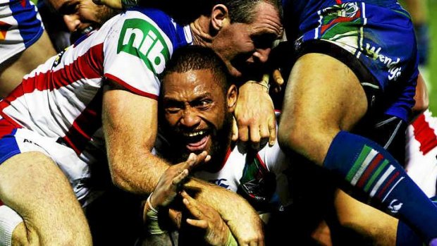Winners are grinners: Manu Vatuvei manages a smile through a pile of Knights bodies after crashing through for a try.