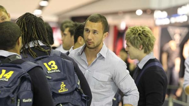 Centre of attention ... Parramatta target Quade Cooper prepares to leave Sydney, bound for South Africa, yesterday with his Wallabies teammates. His future is still up in the air, with rugby league and union competing for his signature.