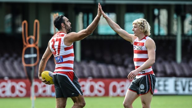 Welcome back: Adam Goodes greeted by Swans youngster Isaac Heeney on his return to Swans training on Tuesday. 