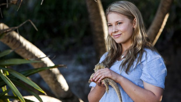 Bindi Irwin cuddles a lizard.