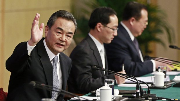 Chinese Foreign Minister Wang Yi  waves at a news conference at the annual session of the National People's Congress (NPC) in Beijing on Sunday.