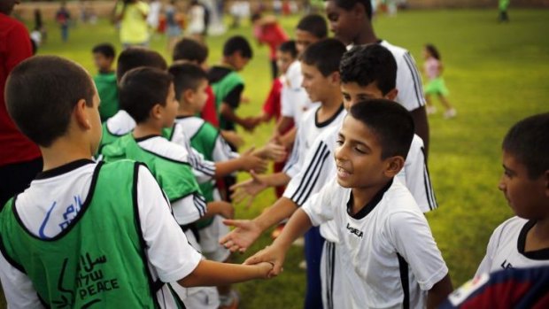 Israeli and Palestinian children shake hands during an event opening a year of training of an Israeli-Palestinian soccer program launched by the Peres Centre for Peace, in Kibbutz Dorot, outside the Gaza Strip.