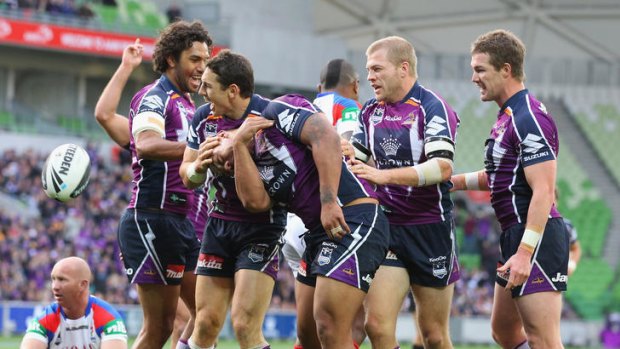 Melbourne Storm players celebrate scoring a try against the Newcastle Knights at AAMI Park.