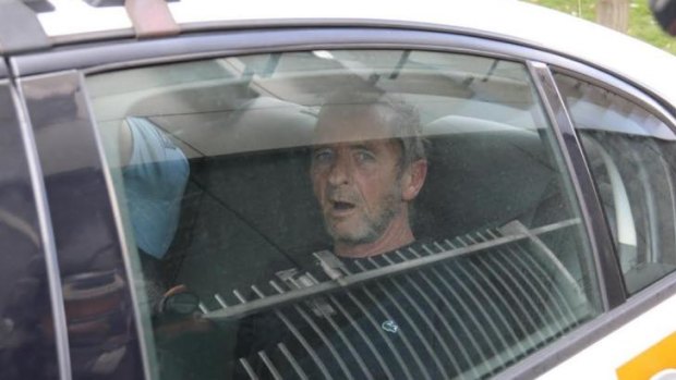Back in cuffs: AC/DC drummer Phil Rudd is taken away in a police car after an incident in Gate Pa.