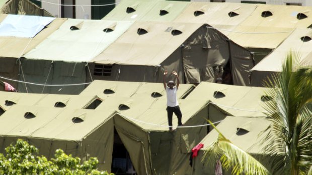 A refugee at the Nauru detention centre protest with signs and chants of freedom.  A view of the Nauru detention centre where Amnesty International say 387 refugees are packed into leaky tents in hot, cramped conditions.
