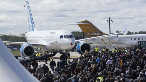 Bombardier employees gather near the new Bombardier CSseries aircraft in Mirabel, Quebec after its maiden flight.