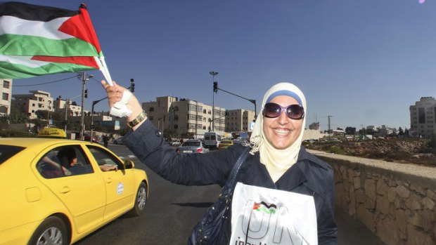 A Palestinian woman shows her support for an upcoming bid for unilateral statehood, in Ramallah on the West Bank.