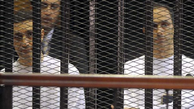 $330 million fortune ... Egypt's former President Hosni Mubarak, centre, and his sons Alaa, left, and Gamal, right, are seen behind bars during a court hearing in Cairo.