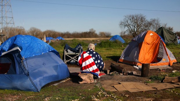 A homeless man wears an US flag jacket at a tent city similar to settlements springing up on the US landscape during the recession.