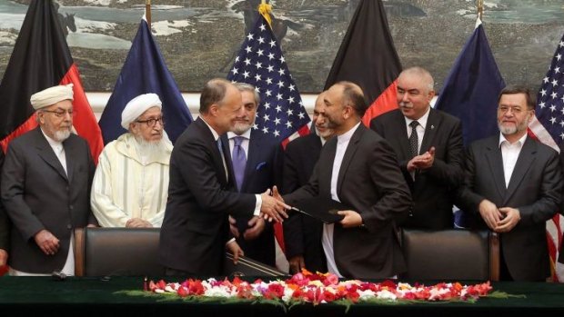 Done deal: US Ambassador James Cunningham and Afghan national security adviser Hanif Atmar shake on it in Kabul.