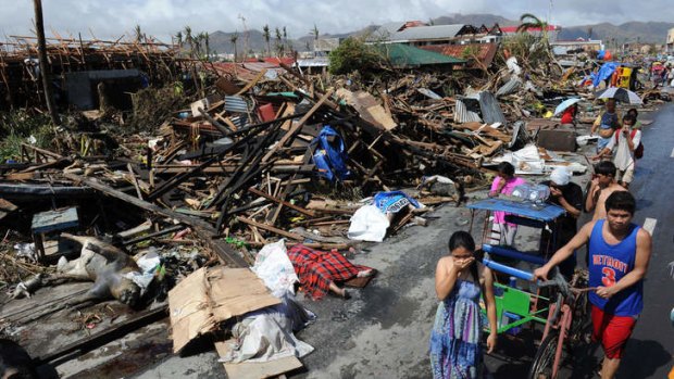 Residents walk past bodies and destroyed houses in Tacloban, the Philippines.
