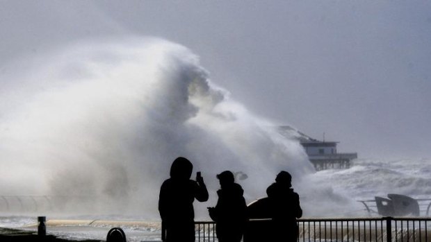 People take photos on the promenade as severe gale force winds hit Blackpool, England.