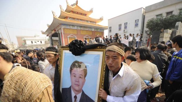 Mourning &#8230; relatives carry a picture of Xue Jinbo, who died in police custody.