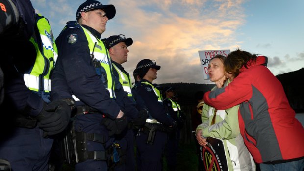 Protesters and police at the Tecoma McDonald's site, where a woman has been removed from the roof this morning.