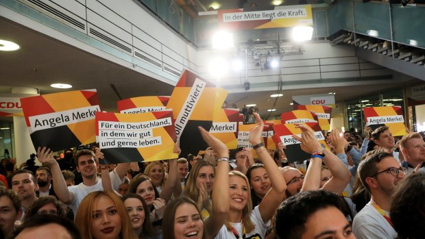 CDU supporters celebrate following the exit polls in the federal election at the party's headquarters in Berlin.