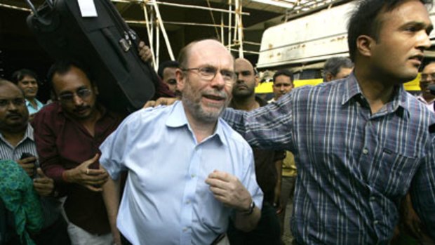 An unidentified British guest is escorted from the Oberoi Trident Hotel.