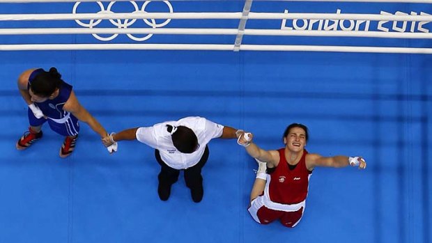 Olympic champion ... Katie Taylor drops to her knees after she is announced as the winner.