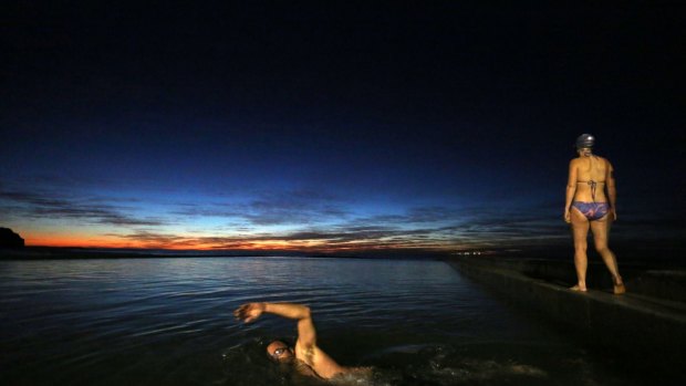 In the pre-dawn darkness on Friday, swimmers take a dip at Austinmer Beach.