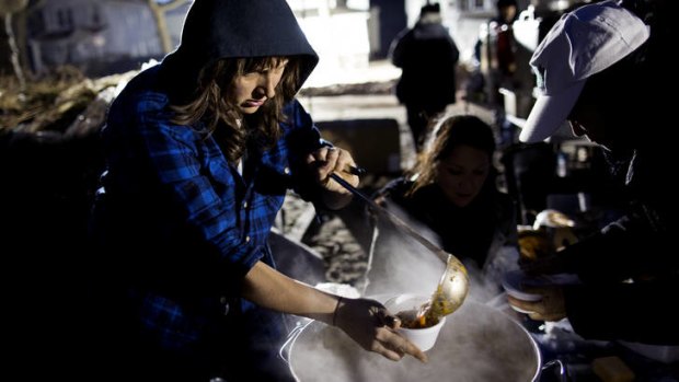 No home comforts &#8230; Ariel Nadelberg ladles hot soup into a cup at a car park in the Rockaways in Queens, where thousands are still without power.
