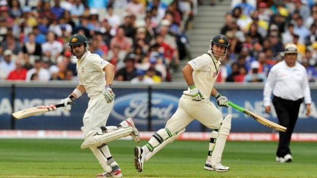 Australian newcomer Ed Cowan (left) and Ricky Ponting cross during their 113-run partnership at the MCG yesterday.