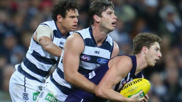 Geelong's Steven Motlop and Tom Hawkins join forces to prevent Fremantle's Zac Dawson from making progress.