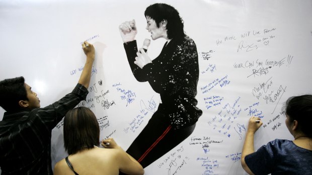 Fans write condolence notes beside Michael Jackson portrait during a rally in memory of him in Kuala Lumpur, Malaysia.