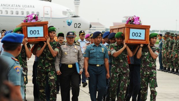 Indonesian soldiers carry coffins containing victims of the AirAsia flight QZ8501 crash at the Indonesian Air Force Military Base in Surabaya.