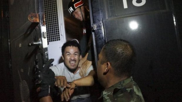 A protester is detained by soldiers at an anti-coup rally in Chiang Mai.