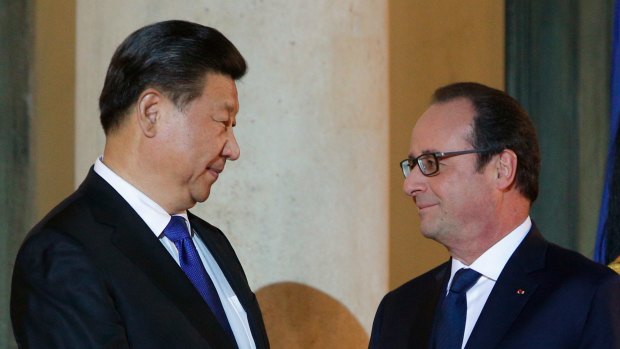 France's President Francois Hollande welcomes Chinese President Xi Jinping prior to a working dinner before the start of the talks.