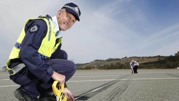 Sergeant Dick Dauth and Senior Constable Jane MacKenzie from the Collision Investigation and Reconstruction Team measuring skid marks.
