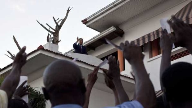 Former dictator Jean-Claude "Baby Doc" Duvalier waves to supporters at his rented house in Port-au-Prince.
