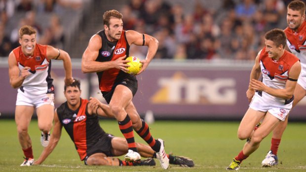 Essendon skipper Jobe Watson powers away from Melbourne's Jack Viney and Jack Grimes.