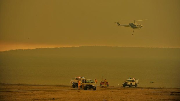 Firefighters waterbomb the blaze near Dawson.