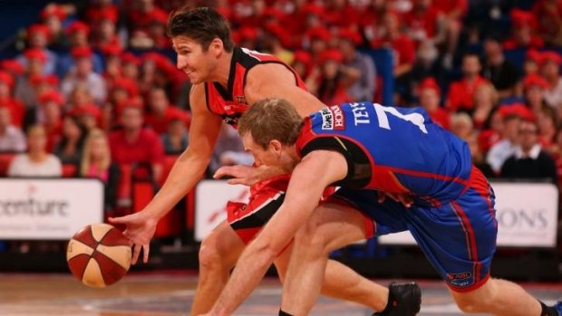 Damian Martin of the Wildcats takes on Brendan Teys of the 36ers.