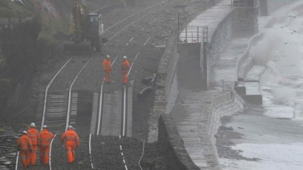 Rail emergency workers inspect damaged track along the seafront at Dawlish in south-west England.
