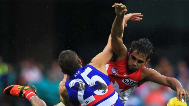 Electrifying &#8230; Sydney's Lewis Jetta collides with Ryan Hargrave of the Western Bulldogs in the wet yesterday.