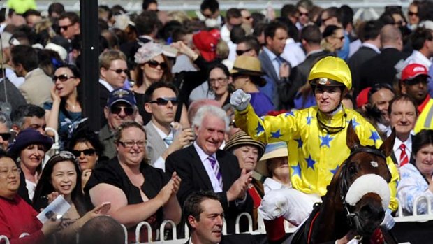 Top of the class: Craig Williams returns to scale in triumph on Caulfield Cup winner Dunaden yesterday.