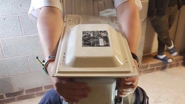 Firefighters spent an hour pulling apart a microwave to rescue a 22-year-old in the UK.